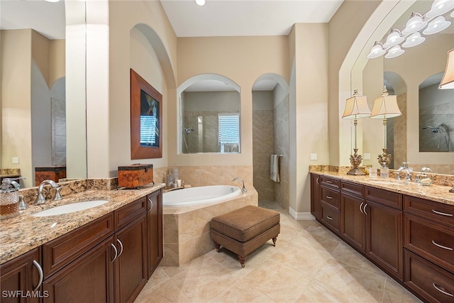 bathroom featuring vanity, plus walk in shower, and tile patterned flooring