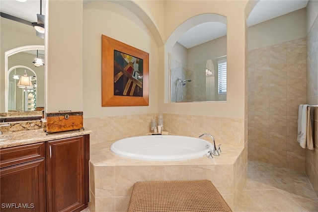 bathroom with tile patterned flooring, ceiling fan, independent shower and bath, and vanity