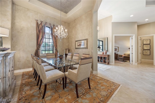 dining room featuring a towering ceiling, light tile patterned floors, and a notable chandelier