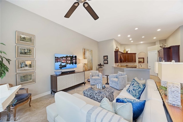 living room with ceiling fan, sink, and light tile patterned floors