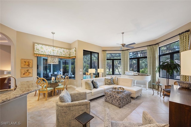 living room with light tile patterned floors, sink, and ceiling fan