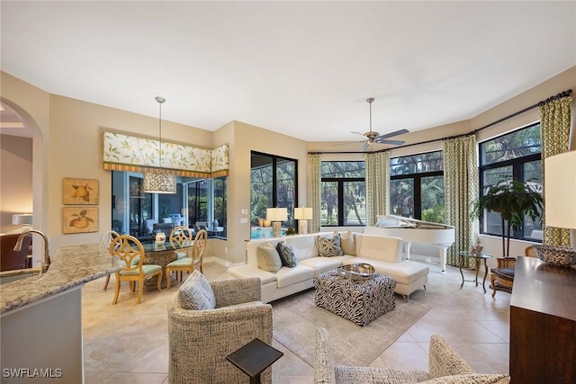 7721 Classics Dr, Naples, FL 34113 - living area with arched walkways, a ceiling fan, and light tile patterned flooring