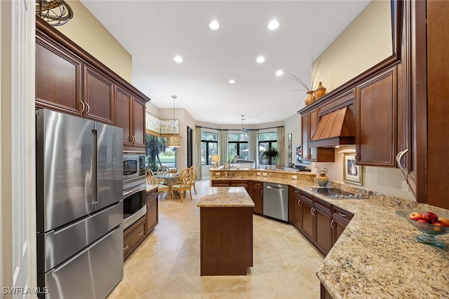 kitchen featuring kitchen peninsula, stainless steel appliances, a center island, decorative light fixtures, and sink