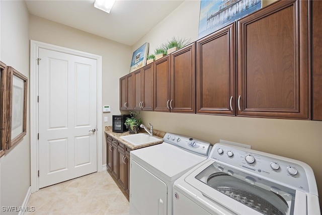 laundry area with cabinets, washing machine and clothes dryer, light tile patterned flooring, and sink