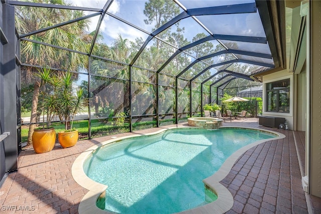 view of pool with a lanai, an in ground hot tub, and a patio area