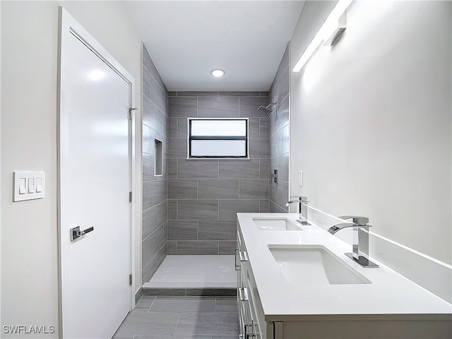 full bathroom with double vanity, a shower stall, and a sink