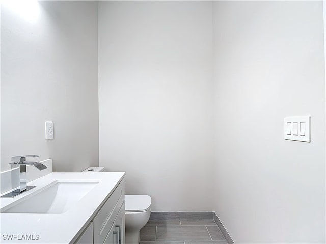 bathroom featuring tile patterned floors, toilet, and vanity