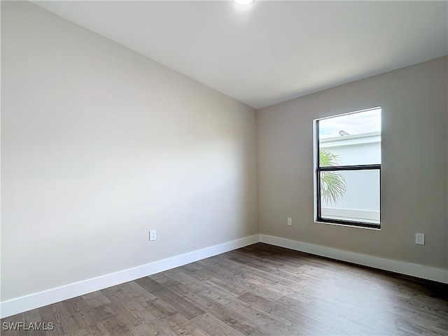 empty room with wood finished floors and baseboards