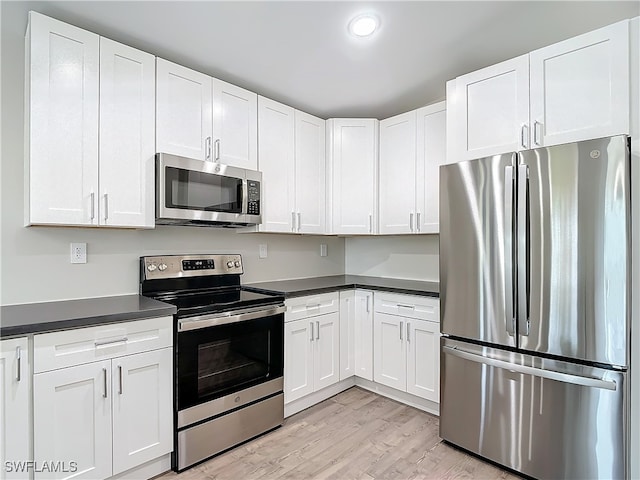 kitchen with light wood-type flooring, white cabinets, and stainless steel appliances