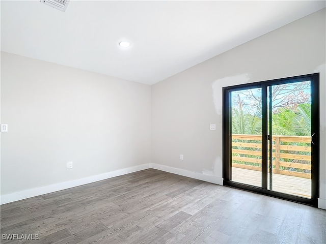 unfurnished room with visible vents, baseboards, and wood finished floors