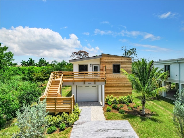 view of front of home with a garage and a front lawn