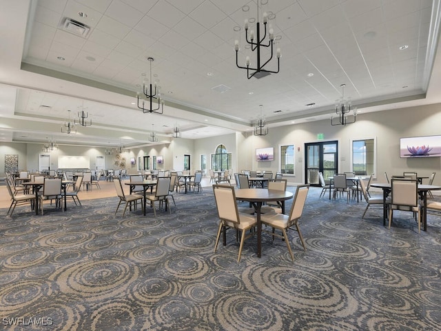 dining area with dark carpet and a tray ceiling