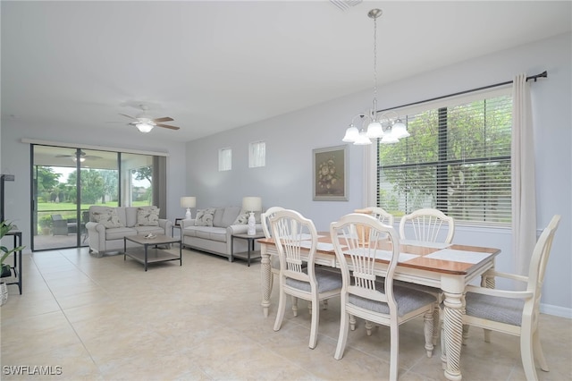 dining room featuring ceiling fan with notable chandelier, a wealth of natural light, and light tile patterned flooring