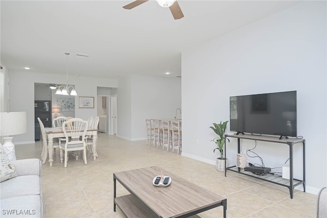 living room featuring ceiling fan with notable chandelier and light tile patterned floors