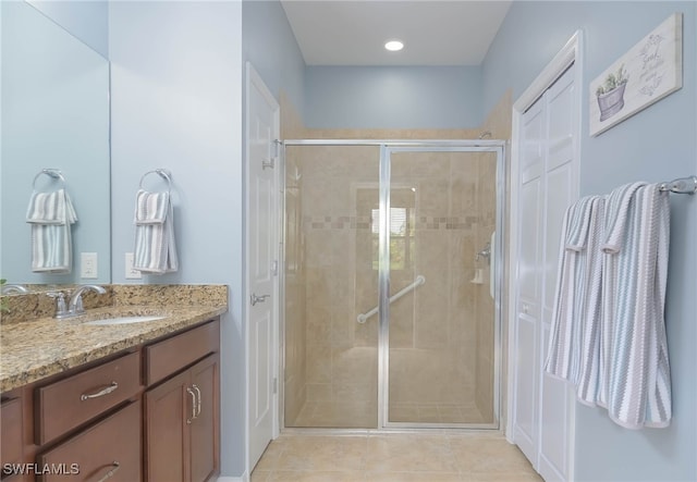 bathroom with tile patterned flooring, a shower with door, and vanity