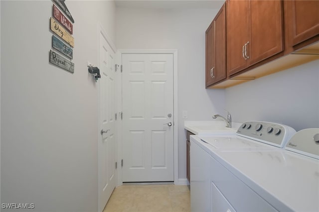 laundry room featuring washing machine and clothes dryer, cabinets, sink, and light tile patterned floors