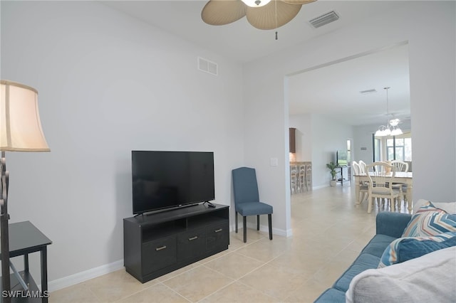 living room featuring light tile patterned floors and ceiling fan with notable chandelier