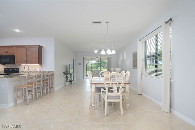 tiled dining area featuring an inviting chandelier