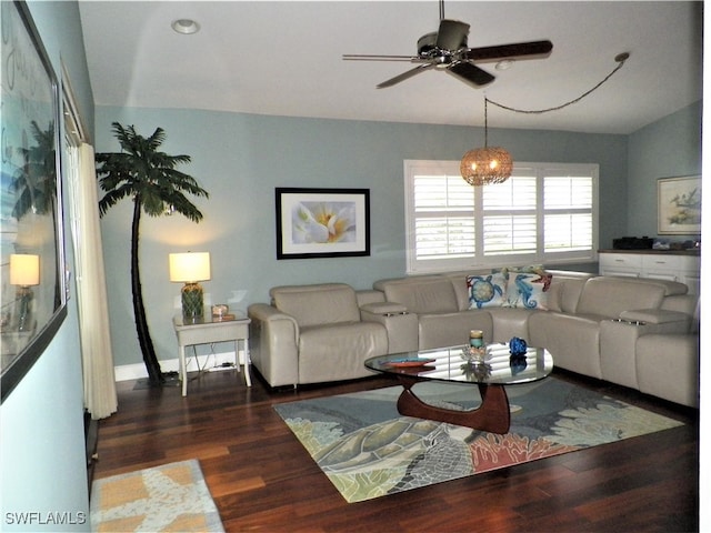 living room with ceiling fan with notable chandelier, lofted ceiling, and dark hardwood / wood-style floors