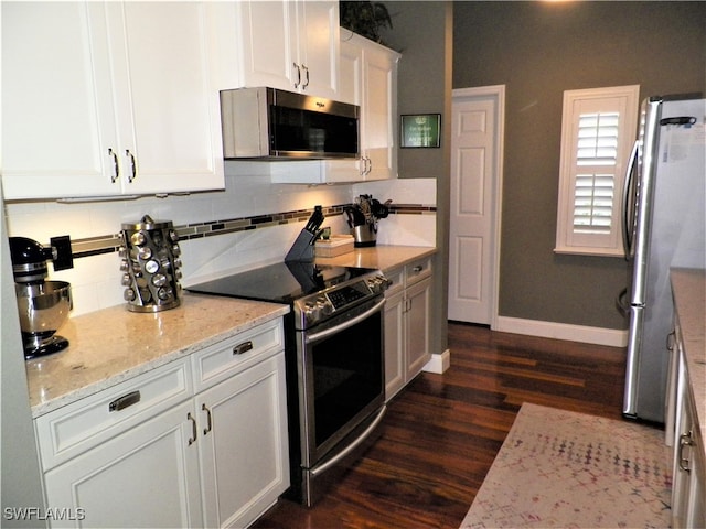 kitchen with light stone countertops, dark wood-type flooring, decorative backsplash, appliances with stainless steel finishes, and white cabinets