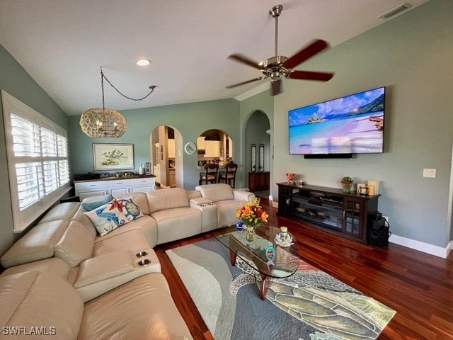 living room with lofted ceiling, ceiling fan with notable chandelier, and dark hardwood / wood-style floors