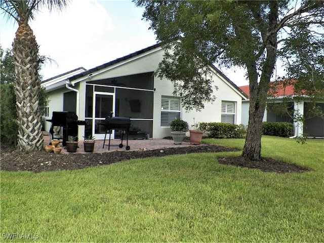 back of house featuring a sunroom, a yard, and a patio