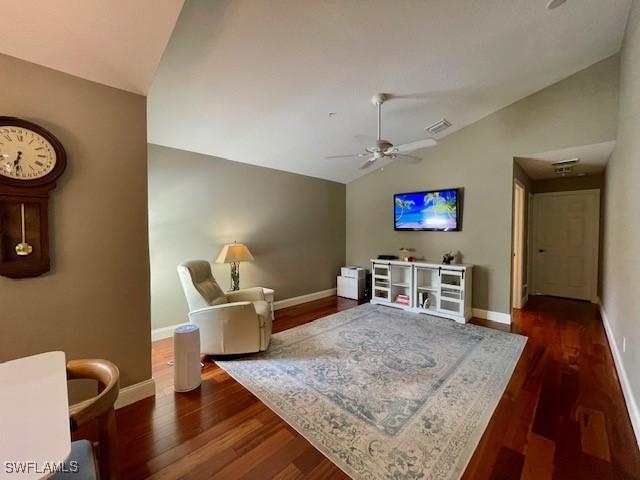 living room featuring lofted ceiling, ceiling fan, and dark hardwood / wood-style floors