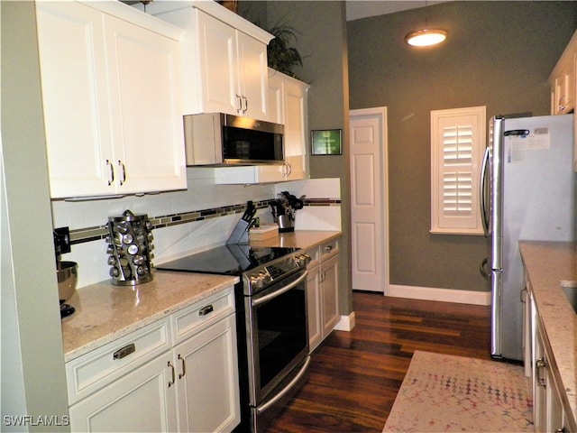 kitchen with dark wood-type flooring, white cabinets, light stone countertops, and stainless steel appliances