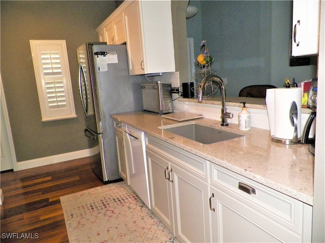 kitchen with hardwood / wood-style floors, stainless steel appliances, sink, light stone countertops, and white cabinets