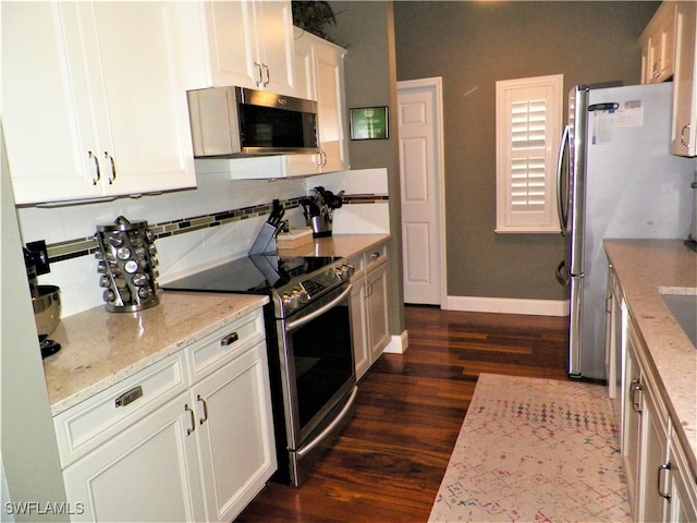 kitchen featuring appliances with stainless steel finishes, light stone countertops, white cabinets, and dark hardwood / wood-style floors