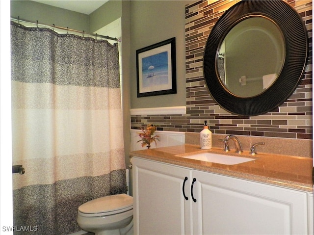 bathroom with vanity, toilet, and backsplash