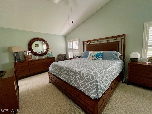 bedroom featuring light colored carpet, ceiling fan, and high vaulted ceiling