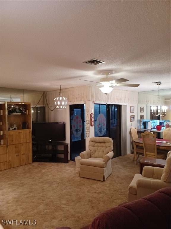 living room featuring ceiling fan with notable chandelier, a textured ceiling, and carpet floors