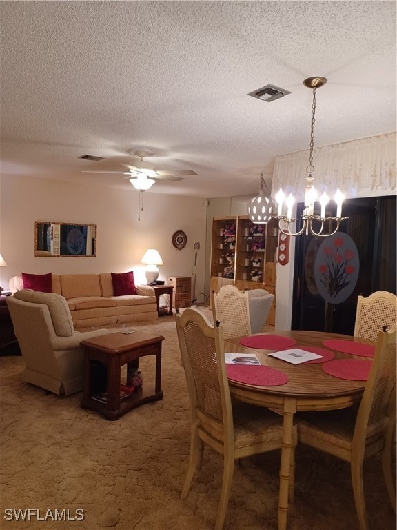 dining area featuring ceiling fan with notable chandelier, carpet, and a textured ceiling