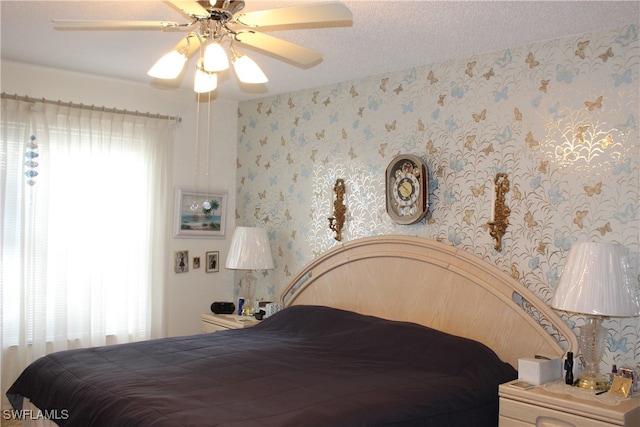 bedroom with multiple windows, ceiling fan, and a textured ceiling