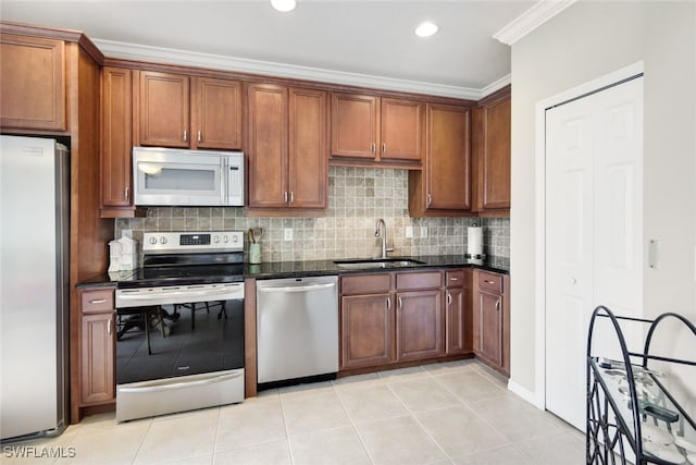 kitchen with ornamental molding, appliances with stainless steel finishes, sink, and light tile patterned flooring