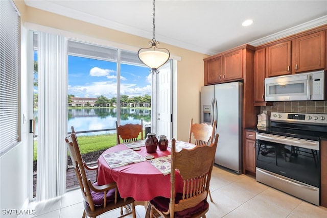 dining space featuring a water view, light tile patterned floors, and ornamental molding