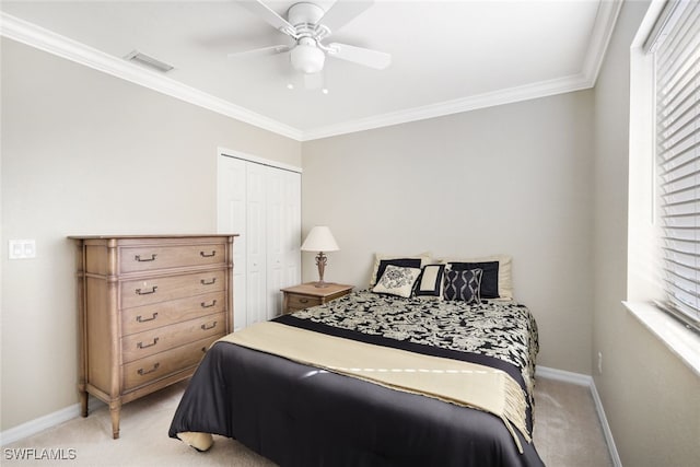 bedroom featuring crown molding, ceiling fan, a closet, and light carpet