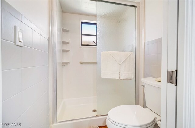 bathroom with walk in shower, tile walls, and toilet