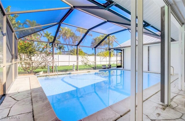 view of swimming pool with glass enclosure and a patio area