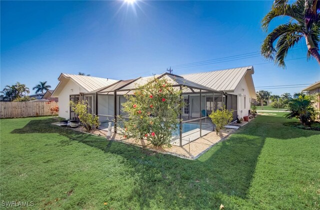 back of property with a yard, a lanai, a fenced in pool, and a patio area