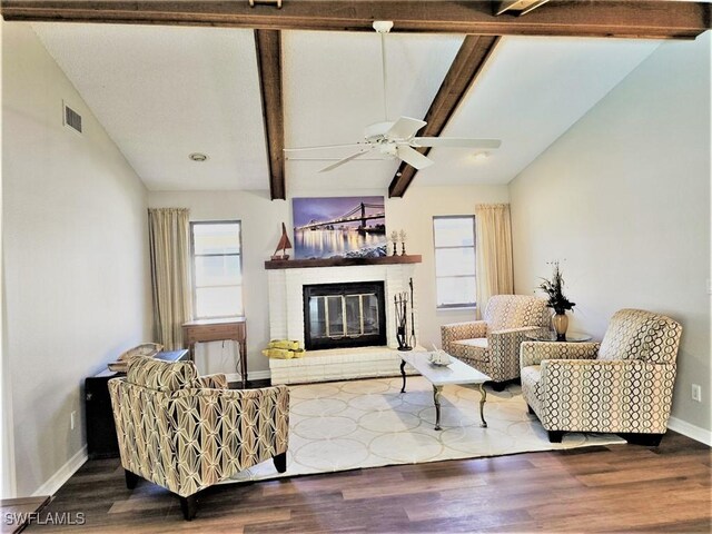 living room featuring wood-type flooring, lofted ceiling with beams, ceiling fan, and a brick fireplace