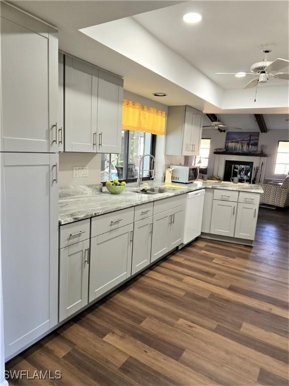 kitchen featuring dark hardwood / wood-style floors, kitchen peninsula, dishwasher, and ceiling fan