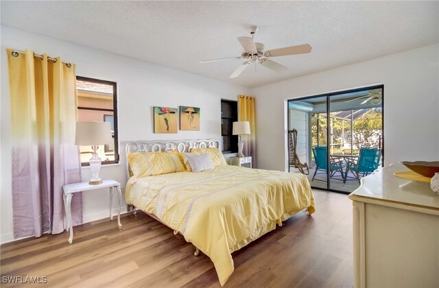 bedroom with ceiling fan, hardwood / wood-style flooring, access to exterior, and a textured ceiling