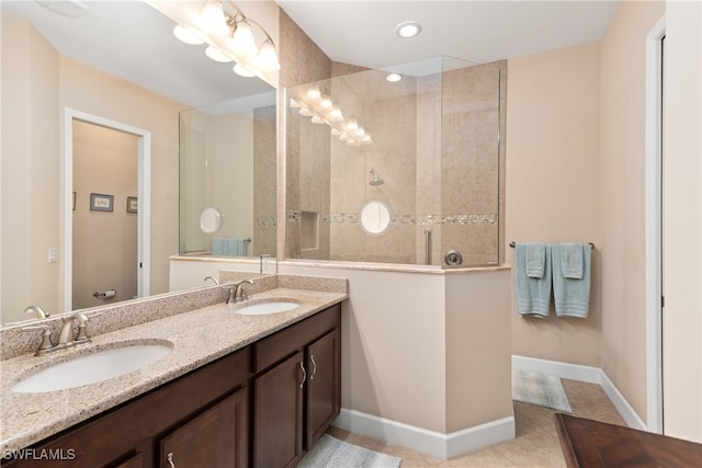 bathroom with vanity, tile patterned floors, and a tile shower