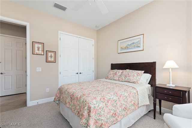 bedroom with ceiling fan, light colored carpet, and a closet