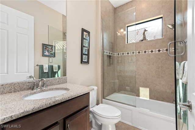 full bathroom with tile patterned floors, bath / shower combo with glass door, toilet, and vanity