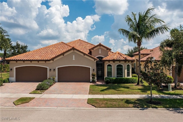 mediterranean / spanish house with a garage and a front yard