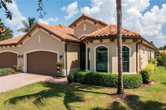 mediterranean / spanish home with a front yard and a garage