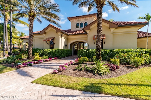 mediterranean / spanish home featuring a front yard